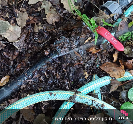 צינור מים עם דליפה באדמה, ברז אדום
